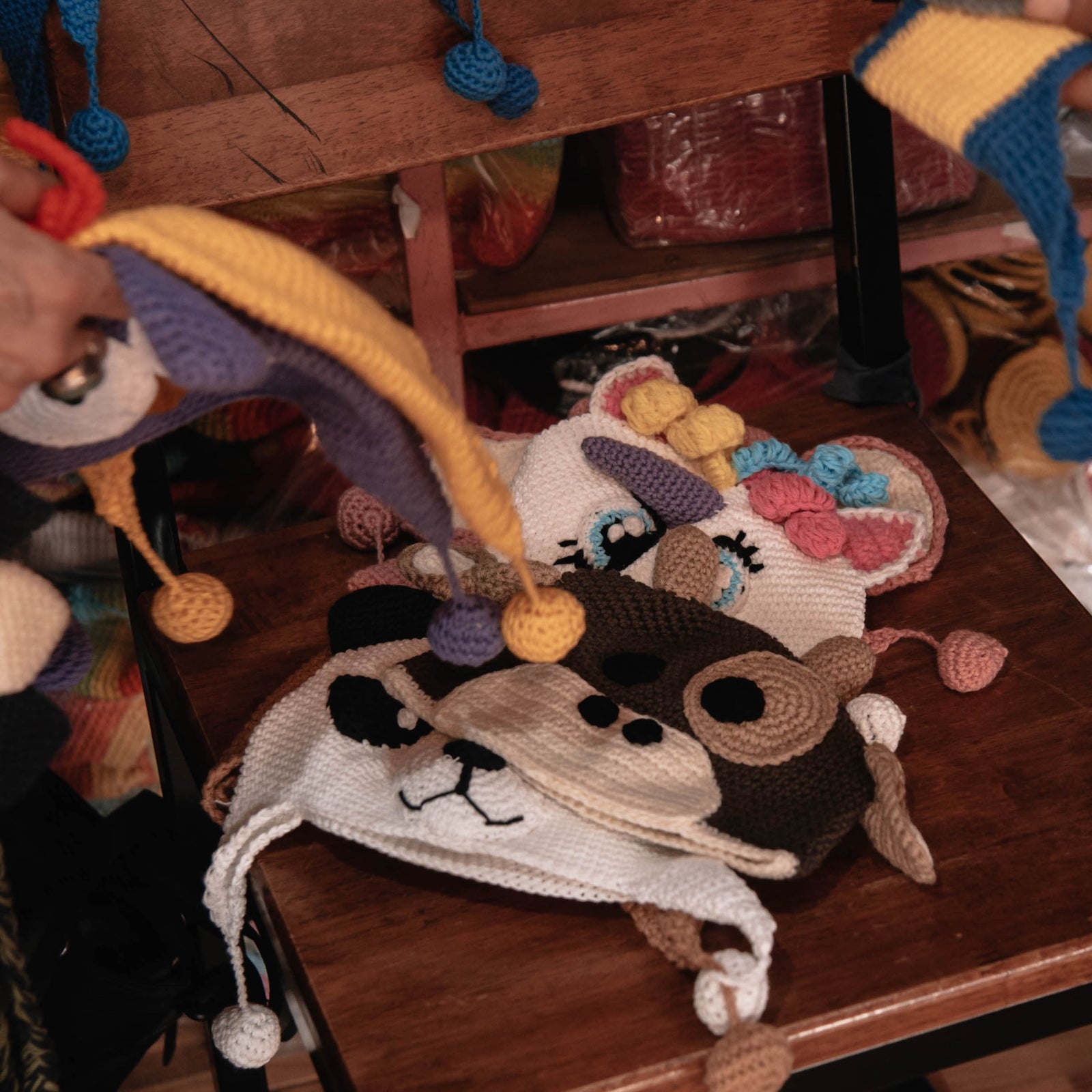 colourful knitted animals hats laid out on a chair