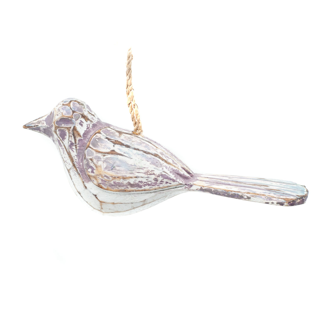 Small driftwood bird ornament on white background hanging from string. 