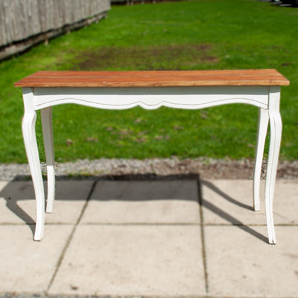 A rustic hallway table with wooden bike and white painted legs