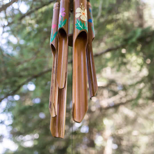 Photo of painted bamboo windchimes hanging in a tree