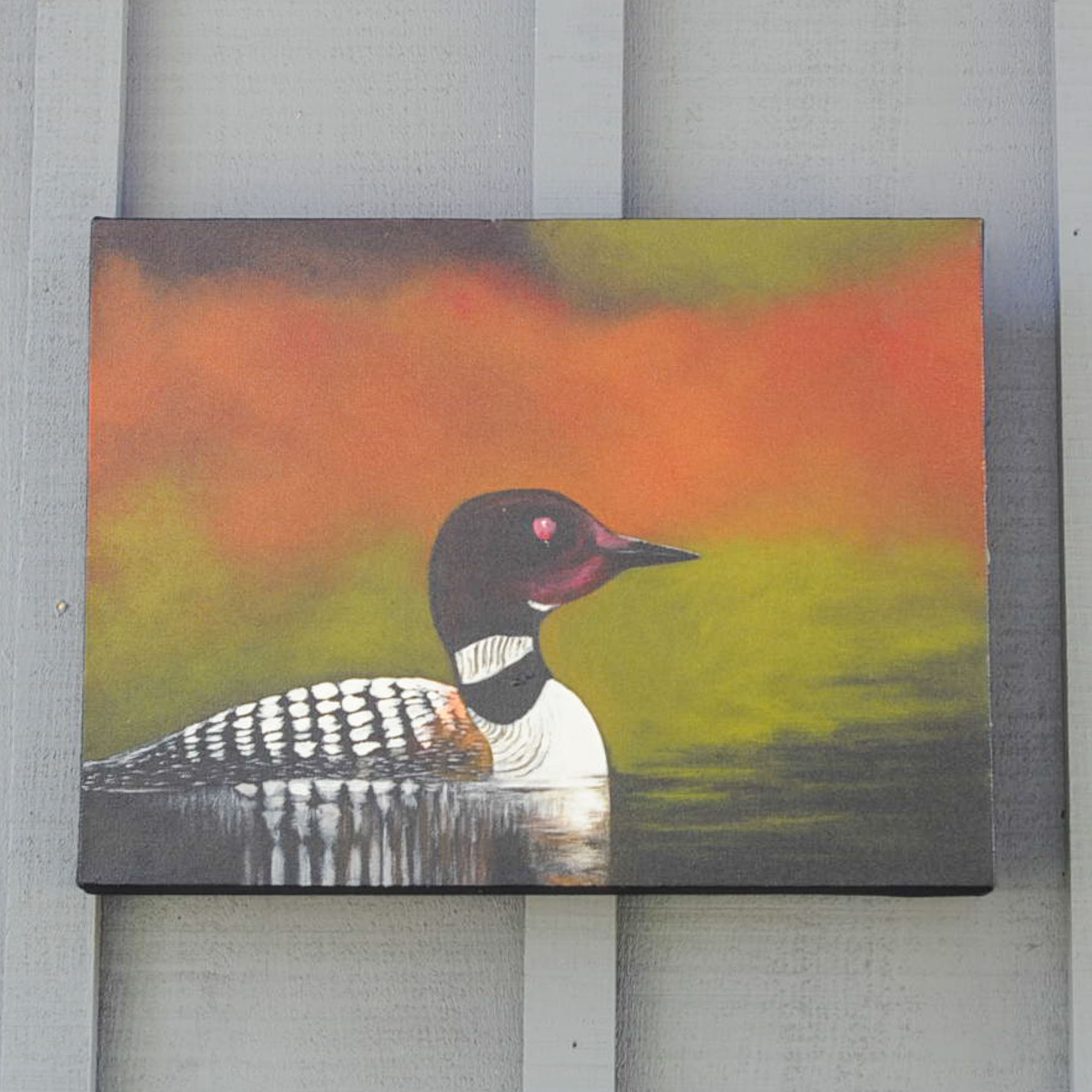 Loon on calm water with fall colours