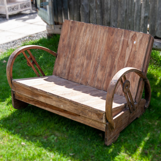 Simple wooden bench in natural wood with a laid back seat and low to the ground