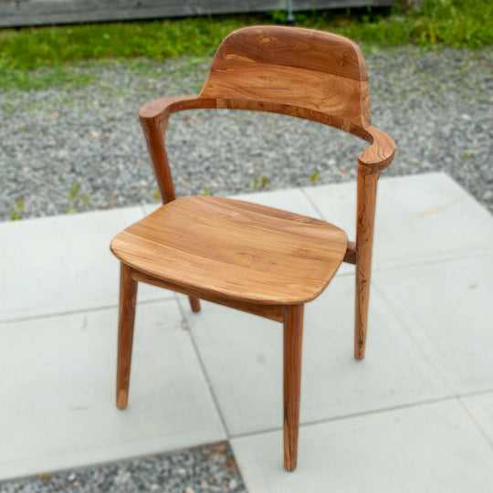 An image of a Javanese Teak Mid-Century Modern (MCM) style dining chair. The chair features a sleek design with clean lines and a minimalist aesthetic. Made from rich teak wood, the dining chair showcases the natural beauty of the wood grain, creating a warm and inviting ambiance.