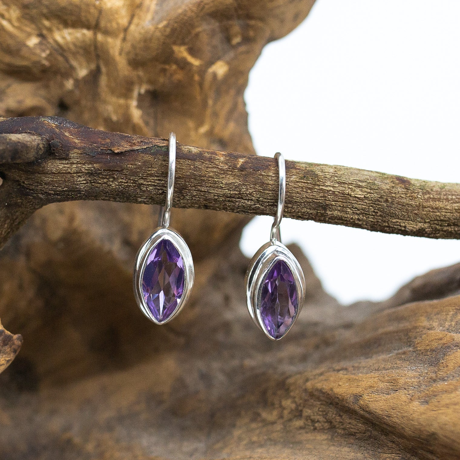 Bali Amethyst Petal Dangle Earrings on wood