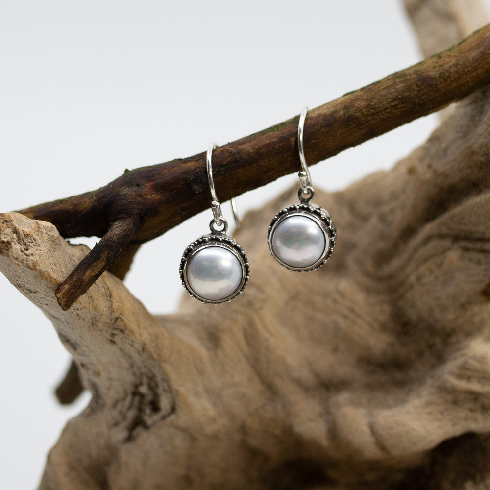 Bali Dot & Swirl Pearl Dangle Earrings on wood