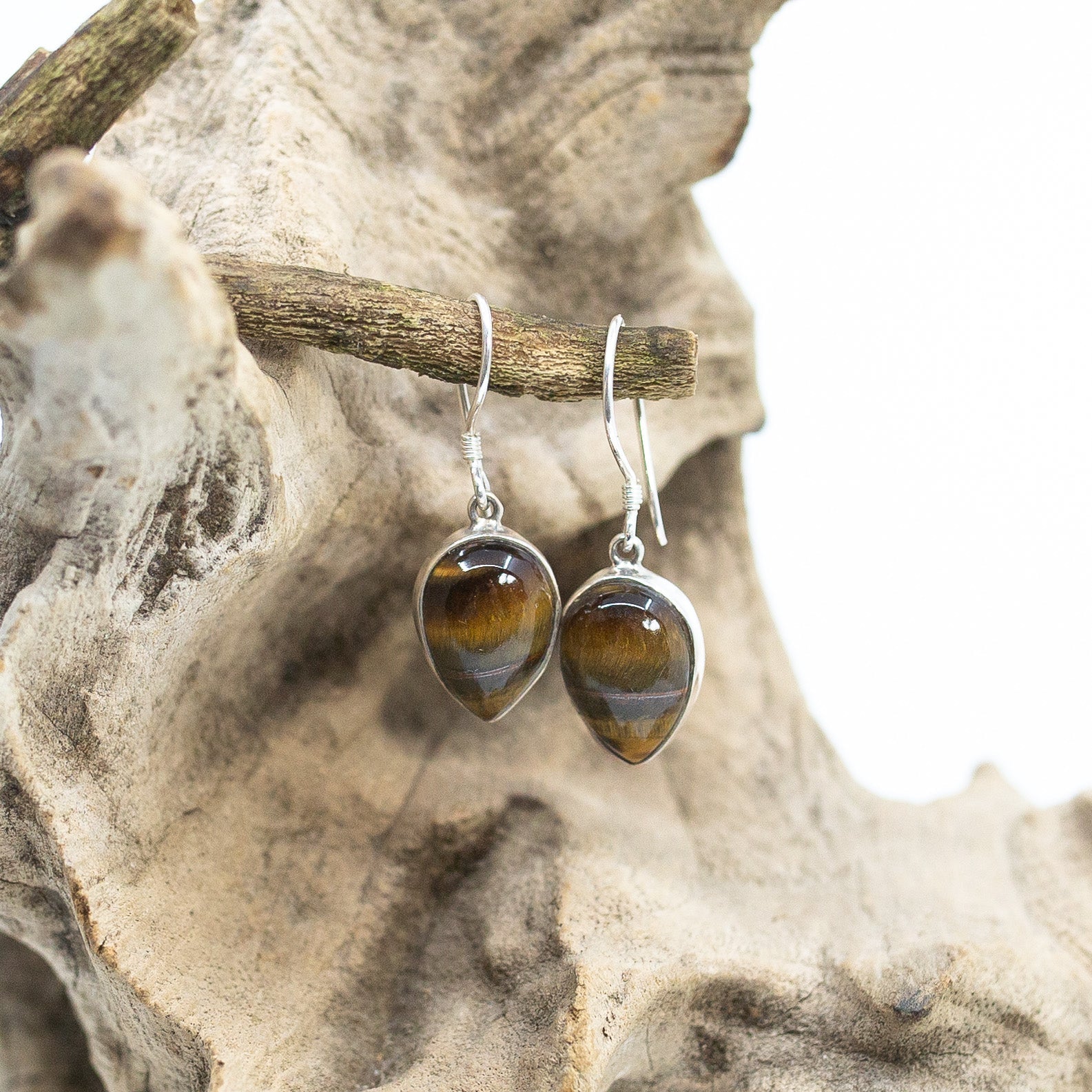 Bali Leaf-Shaped Tiger Eye Dangle Earrings on wood