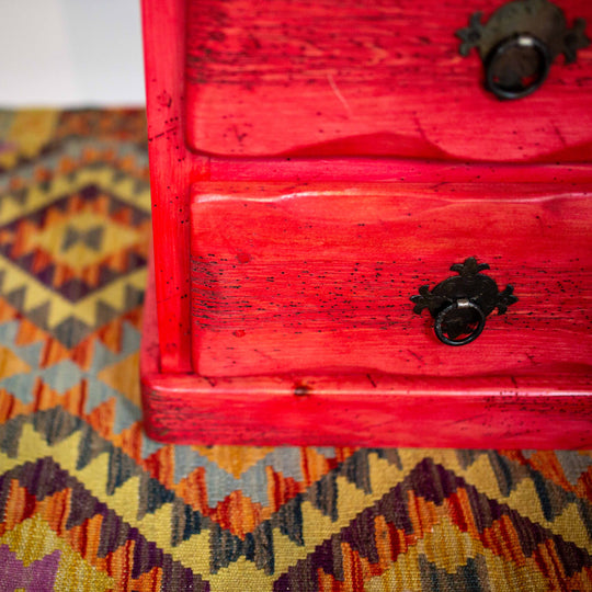 Photo of 4 drawer small mexican dresser in red.