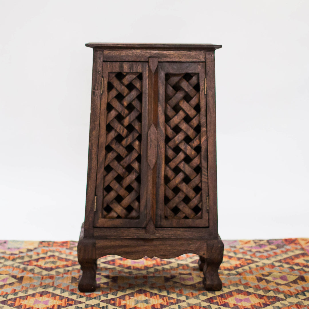 Photo of dark wood cabinet with a single door and intricate carvings