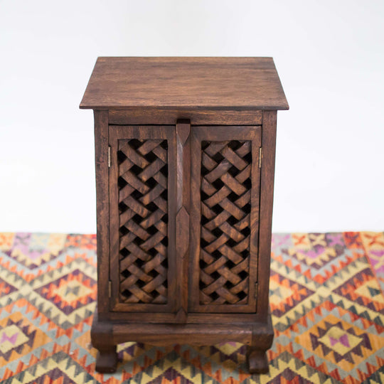 Photo of dark wood cabinet with a single door and intricate carvings