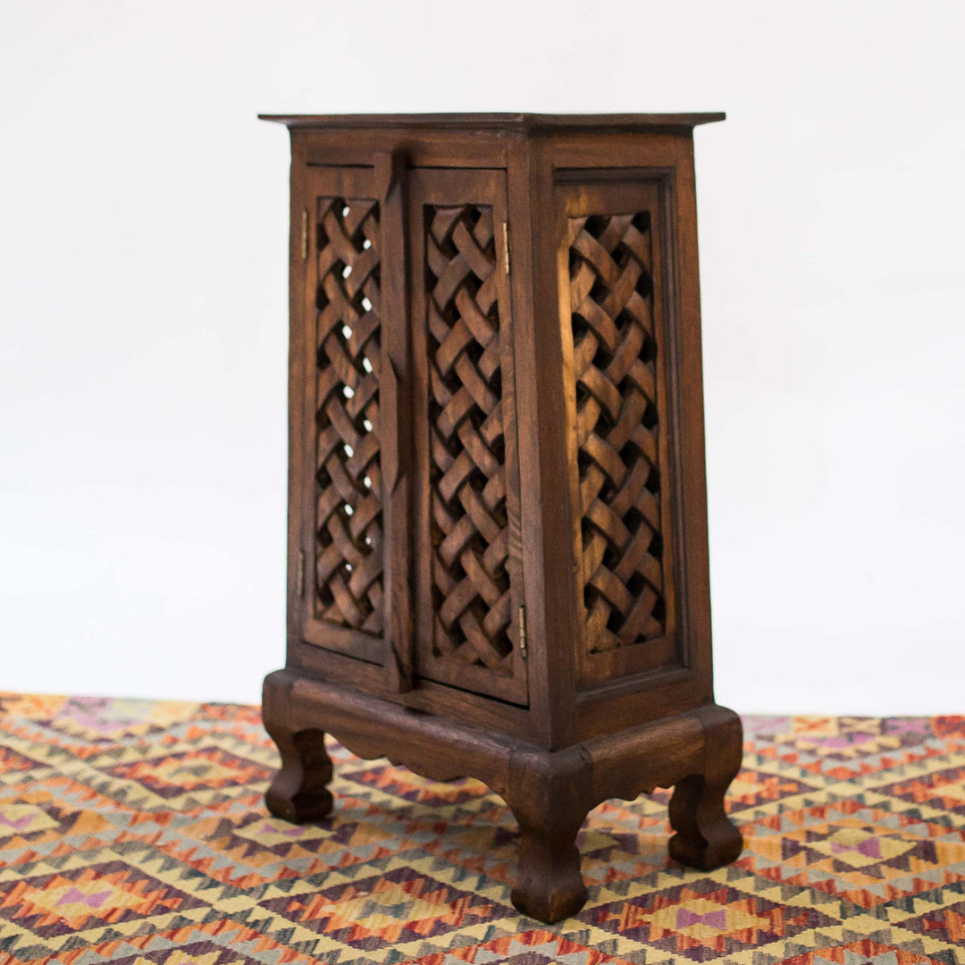 Photo of dark wood cabinet with a single door and intricate carvings