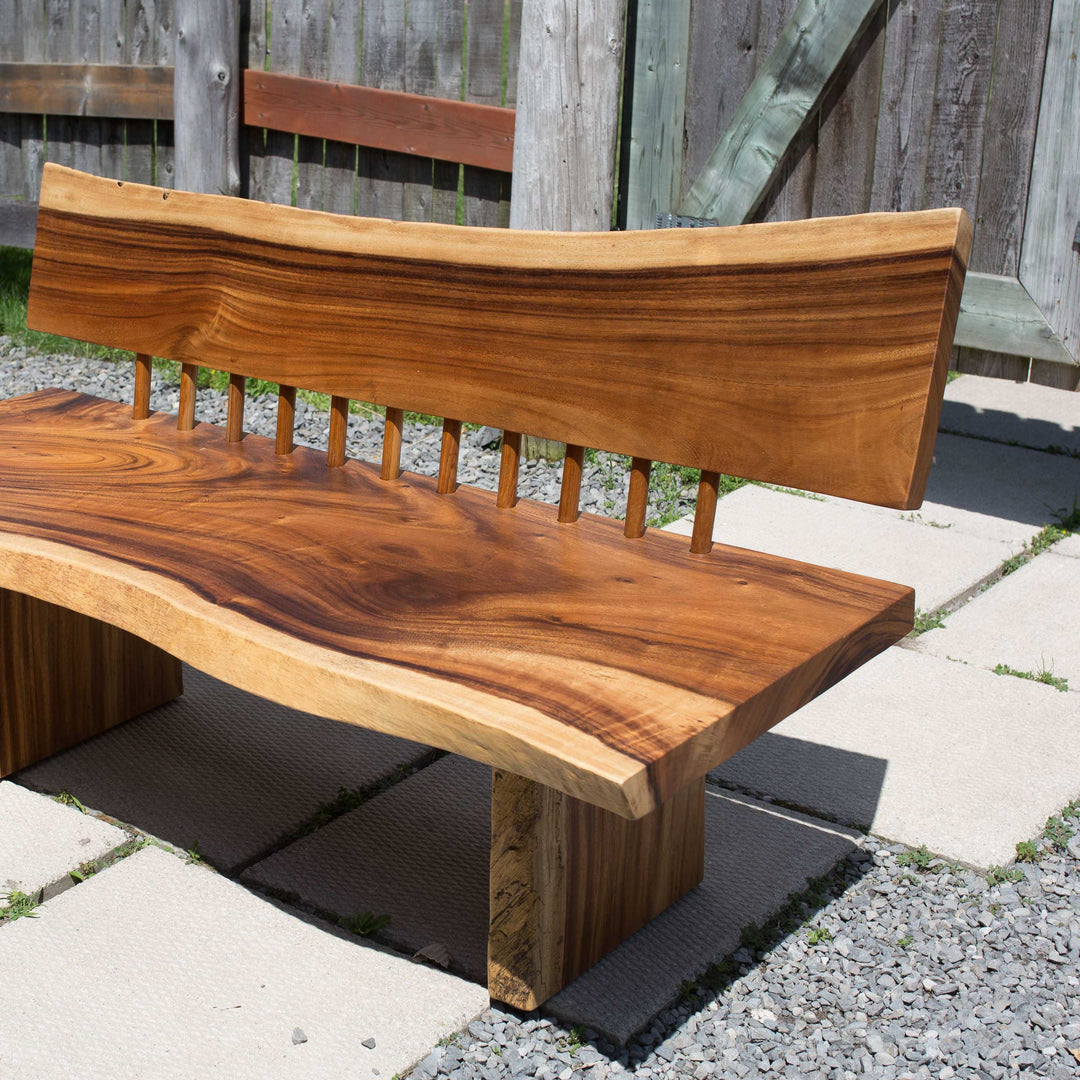 Photo of a sono wood large bench outdoors on a patio against a fence background