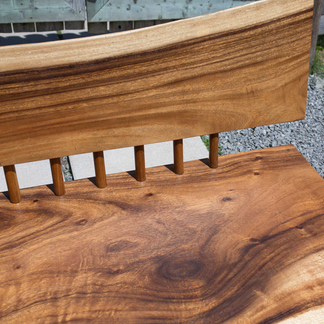 Photo of a sono wood large bench outdoors on a patio against a fence background