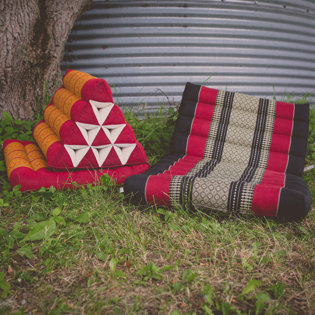 Photo of a folding yoga cushion in various positions, a black colour and a red/orange colour