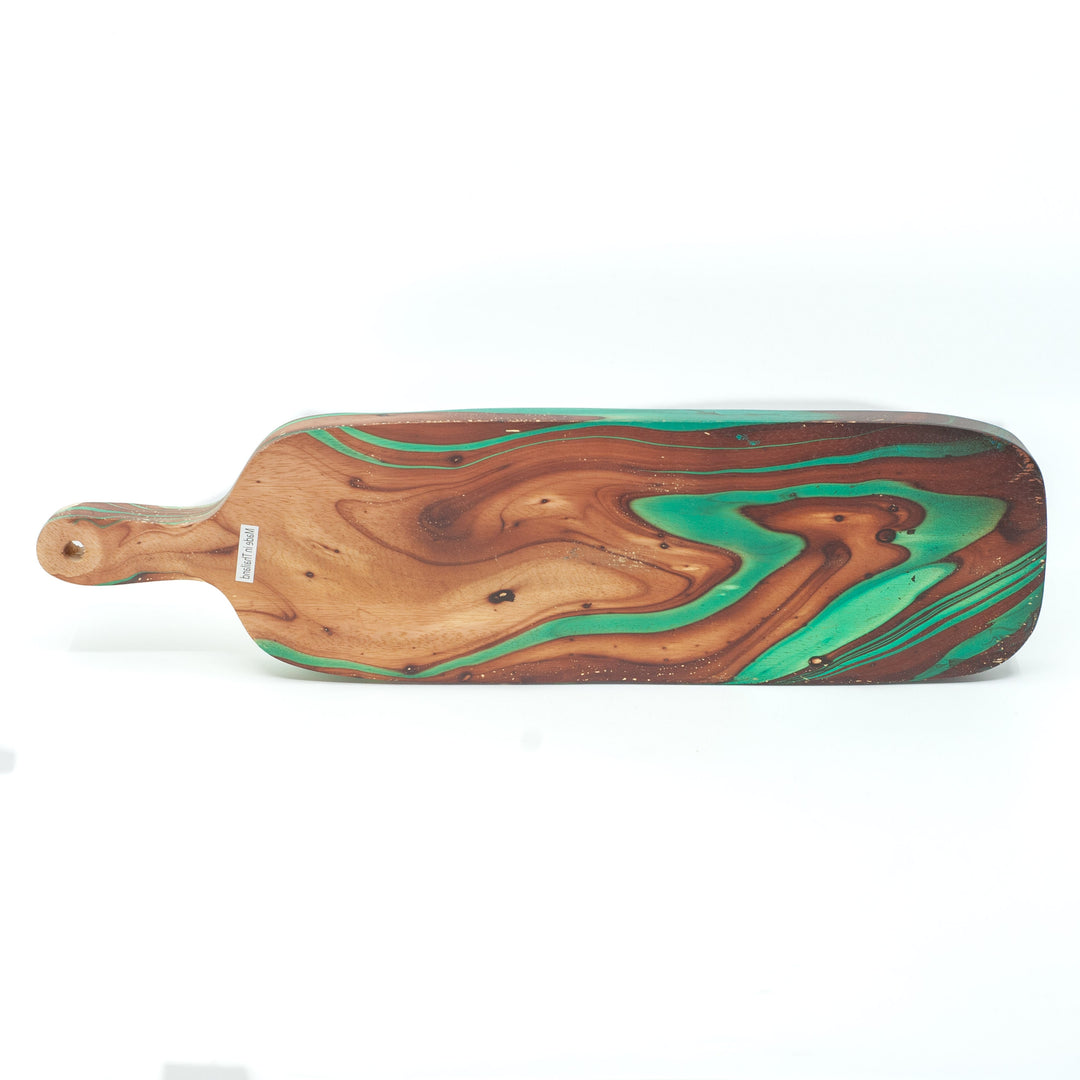 Photo of a mango wood cutting board in various colours featuring a dip dyed pattern